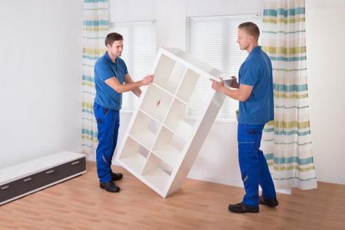 Removal crew carrying furniture from a Kilburn home
