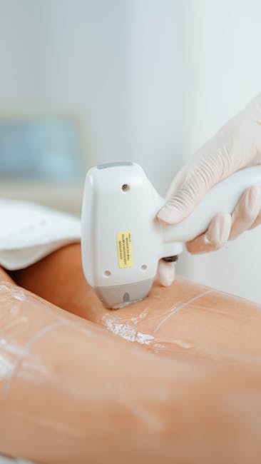 A narrow residential street in Kilburn with a gently curving asphalt road marked by double yellow lines along the edge. On the left side, a weathered metal fence covered in colorful posters and advertisements runs parallel to the pavement, separating the street from an elevated railway bridge painted in dark blue with a metal framework. Underneath the bridge, there is an arched passageway. To the right, a brick wall topped with lush green ivy borders the sidewalk, which is lined with a row of small, multi-story brick houses featuring chimneys and balconies. These residential buildings vary in height and style, with some having metal railings and window shutters. The scene appears to be captured during daylight hours with overcast skies, and there are no visible pedestrians or vehicles. The setting suggests a quiet, urban neighbourhood suitable for house removals and furniture transport, with potential for loading and unloading activities related to home relocation by local removals services such as Man and Van Kilburn.